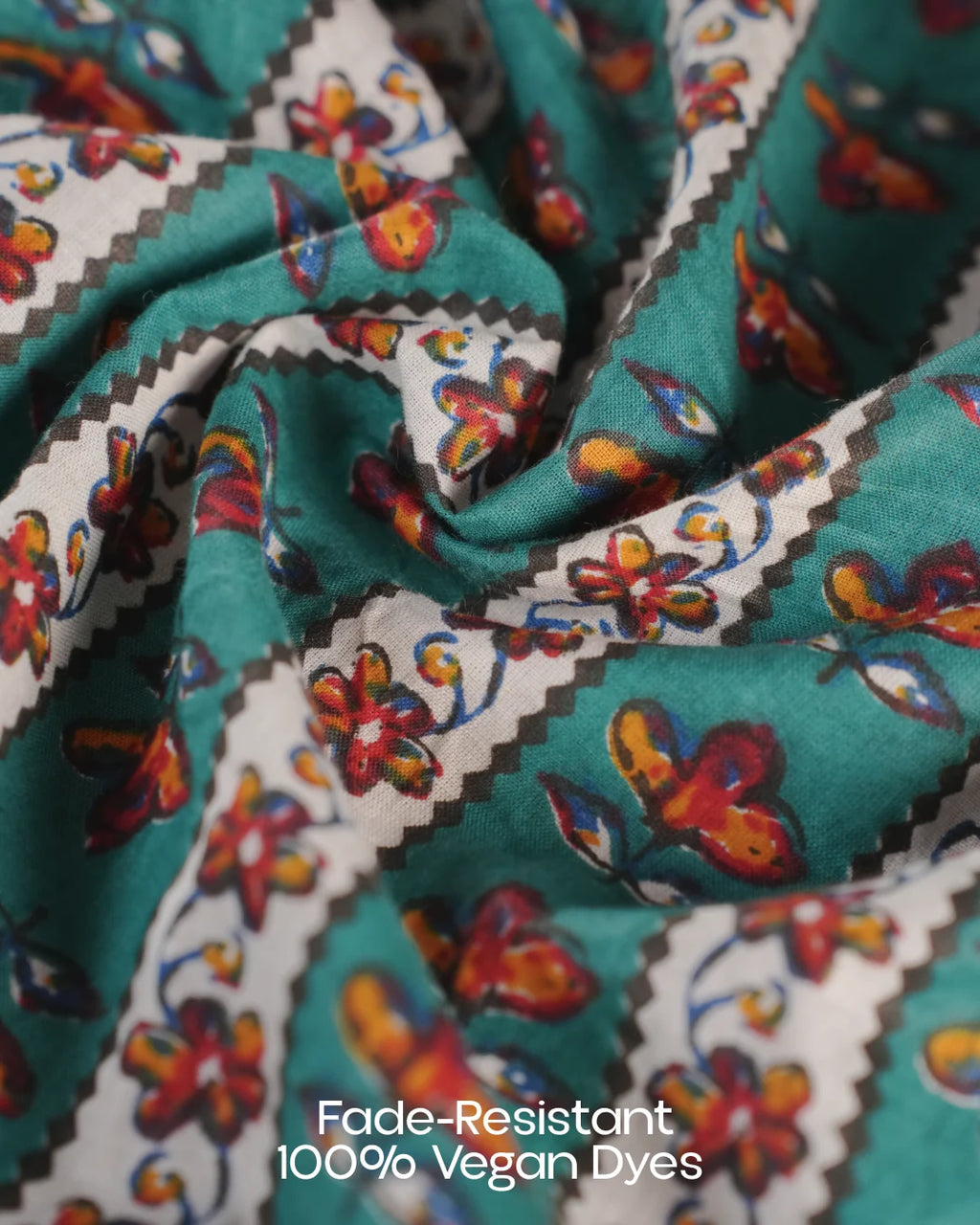 Close-up of fabric with colorful butterfly pattern and text 'Fade-Resistant 100% Vegan Dyes'.