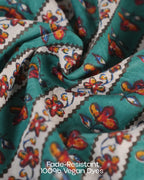 Close-up of fabric with colorful butterfly pattern and text 'Fade-Resistant 100% Vegan Dyes'.